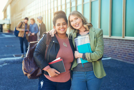 Friends made in college are friends for life. college students between classes on campus grounds.の写真素材