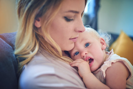 Since day one she snuggled right into moms heart. an adorable baby girl bonding with her mother at home.の写真素材