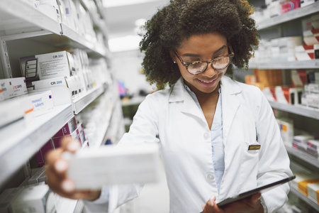 Ive been looking for this. a cheerful young female pharmacist checking stock on the shelves of a pharmacy.の写真素材