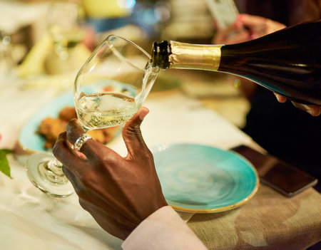This calls for a celebration. an unrecognizable man pouring champagne.の写真素材