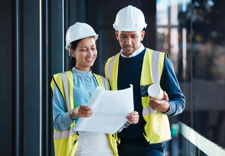 Architect, construction engineers and builder partners with building blueprints planning together....