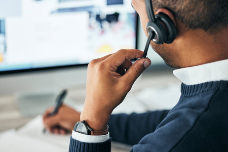 Call center, customer service and agent assisting online customer with a headset and taking notes....
