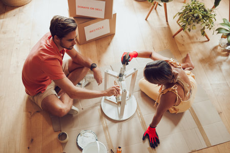 Recycle, thrift furniture and painter couple painting wooden table for new creative project in an apartment. Above view of man and woman working on DIY home improvement with a reusable craft objectの写真素材