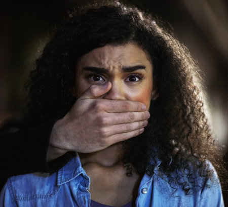 In a desperate situation. Portrait of a young woman being grabbed by a criminal in the city.