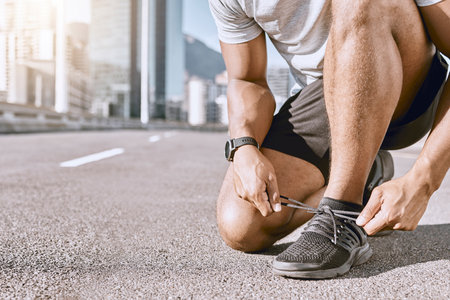 Runner getting ready for fitness running in city street, cardio training workout in town and preparing for exercise in road downtown. Active male jogging, exercising and doing physical activityの写真素材
