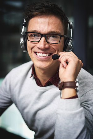 Lets see what I can do for you. Cropped portrait of a handsome young businessman working late in a...