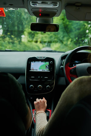 Just follow the GPS. Rearview shot of a young couple sitting in their car ready to depart on their roadtrip.の写真素材