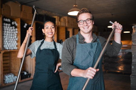 Wine making workers with press tool or equipment inside a cellar, winery or distillery warehouse with bulk quality alcohol. Woman, man or sommelier people with smile portrait for industry backgroundの写真素材