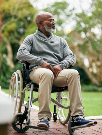 Getting some fresh air. Full length shot of a handsome senior man sitting in his wheelchair outside.の写真素材