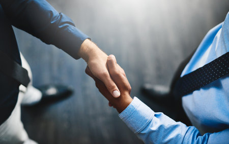 The deal is done. two unrecognisable businesspeople shaking hands in an office.
