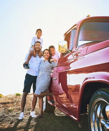 Taking the family on a road trip vacation. a cheerful family posing for a portrait together outside next to a red pickup truck.の写真素材