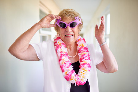 I still have fun at my age. a carefree elderly woman wearing pink glasses and posing inside of a...