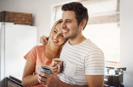 Love sure makes life amazing. a happy young couple enjoying coffee together in the morning at home.の写真素材