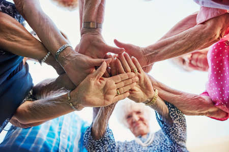 Do not tire when you retire, get inspired. Low angle shot of seniors hands huddled together outside.の写真素材