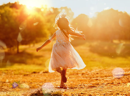 I want to be a kid forever. an adorable little girl playing outdoors.の写真素材