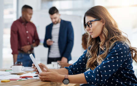She motivates her team by being a hard worker. creative employees working in a modern office.の写真素材