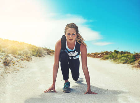 Ready, set, go time to exercise. a sporty young woman getting ready to run outdoors.