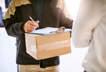 Please sign here. a courier making a delivery to a customer.の写真素材