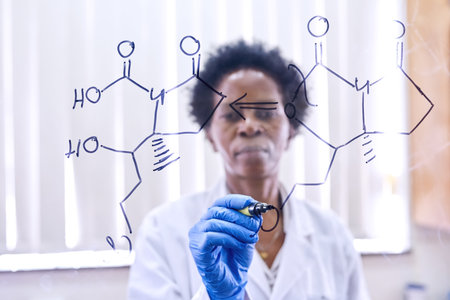 Making groundbreaking discoveries. a female scientist drawing molecular structures on a glass wall in a lab.の写真素材