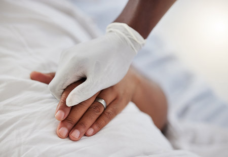 Doctor, healthcare worker and medical professional holding hands to show support, consulting with sick hospital patient and giving healthcare to person. People helping with insurance and surgeryの写真素材