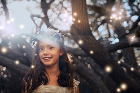 Children always see the magic in life. Portrait of a little girl playing outside.の写真素材