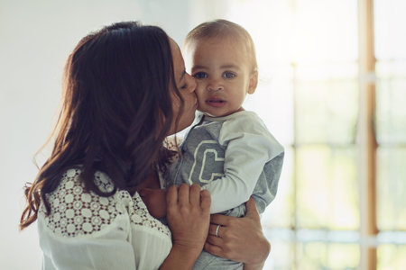 Just a little more kisses before you not little anymore. a mother kissing her adorable baby boy on...