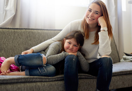 Weekends are mommy and daughter time. a mother and her little girl posing together on the couch at...