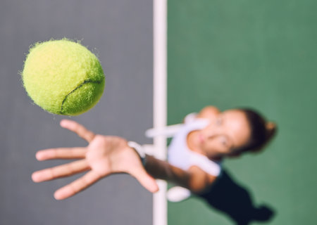 Tennis ball, sports and female player throwing and serving on a court outside from above. Athletic woman playing game for competitive fun with copy space. Sporty woman preparing for a gameの写真素材