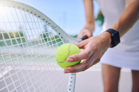 Closeup tennis ball, racket and sport for fit, active and healthy player training and exercising for practice. Professional player getting ready to serve for routine court workout and exercise matchの写真素材