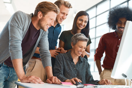 Nothing feels better than a completed project. a group of creative designers hard at work in their modern office.の写真素材