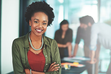 My team and I have become pioneers in the industry. Portrait of a businesswoman standing in an office with her colleagues in the background.の写真素材