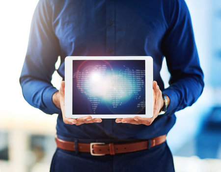 Its your connection to the world. Closeup shot of an unrecognisable businessman holding a digital tablet.の写真素材