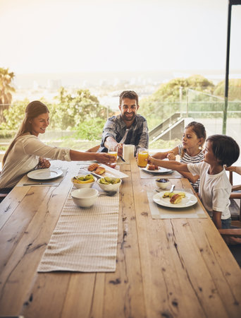 Time to dig in and enjoy a hearty breakfast together. a family having breakfast together at home.の写真素材