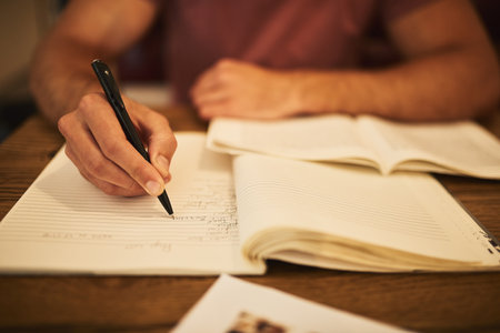 This test wont get the best of him. an unidentifiable young student studying alone at a cafe table.の写真素材