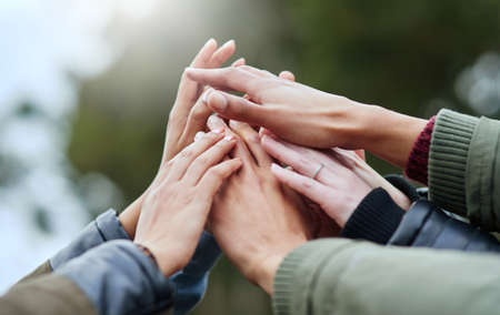 Reaching for their dreams together. Closeup shot of a group of friends with their hands together in...