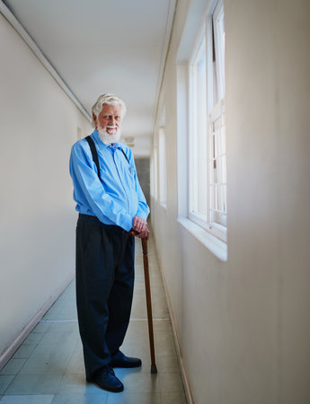 Its good to be a pensioner. Portrait of a happy senior man posing in the hallway of his nursing home.の写真素材