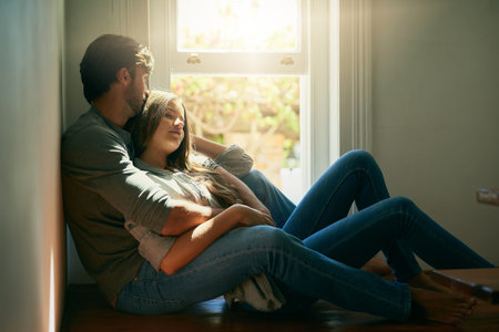 What are you thinking about. an affectionate young couple holding each other in the sunlight.