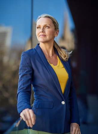 Shes got some big ambitions. a mature businesswoman looking thoughtful while standing outside.の写真素材