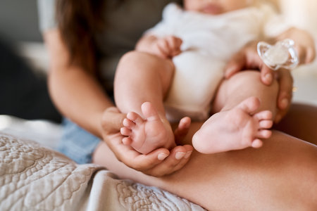 Tiny baby toes are the cutest thing in the world. a mother holding her babys feet.の写真素材