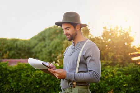 The admin side of farming. a young man checking the stock in his garden.の写真素材