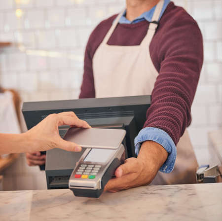 Making payments even simpler. an unidentifiable woman making a payment with her cellphone in a...