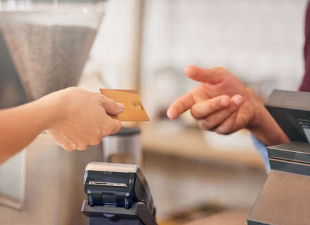 She never forgets to tip her server. an unidentifiable woman making a payment with her credit card...