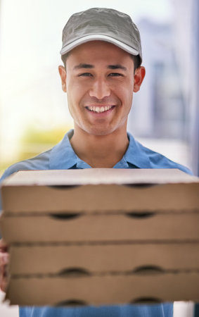 From our ovens to your door. Portrait of a happy deliveryman holding a stack of pizza boxes.