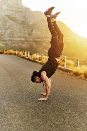 With every work out he just gets stronger. a young man exercising outdoors.