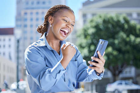 Happy, excited and celebrating while reading on phone and woman feeling like a winner while cheering...