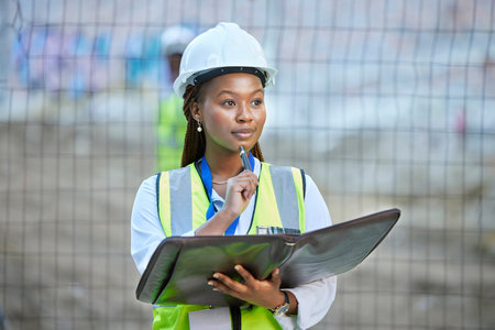 Construction worker, maintenance and development woman thinking with documents at work. Building management employee with a vision for improvement or plan for contractor or builder at the job site.の写真素材