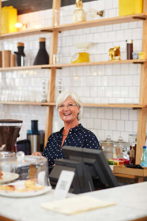 Dont ever stop chasing your dreams. Portrait of a senior woman working in a coffee shop.の写真素材