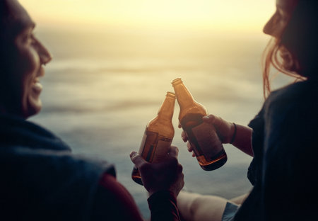 Heres to the view. an affectionate young couple toasting with beers atop a mountain.の写真素材