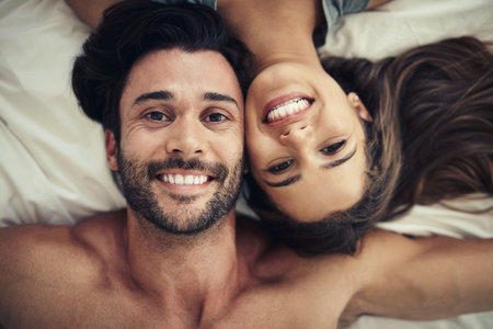 Theres no place Id rather be. an affectionate young couple relaxing in bed together.の写真素材