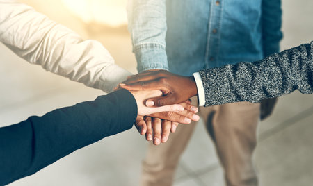 Give your best, be the best. a group of businesspeople joining their hands in solidarity.